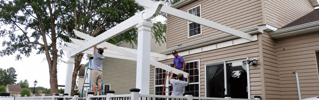 Crew installing large white beams for a custom pergola | Blue Rock Roofing & Construction | Best porch and pergola installation in Fort Mill, SC