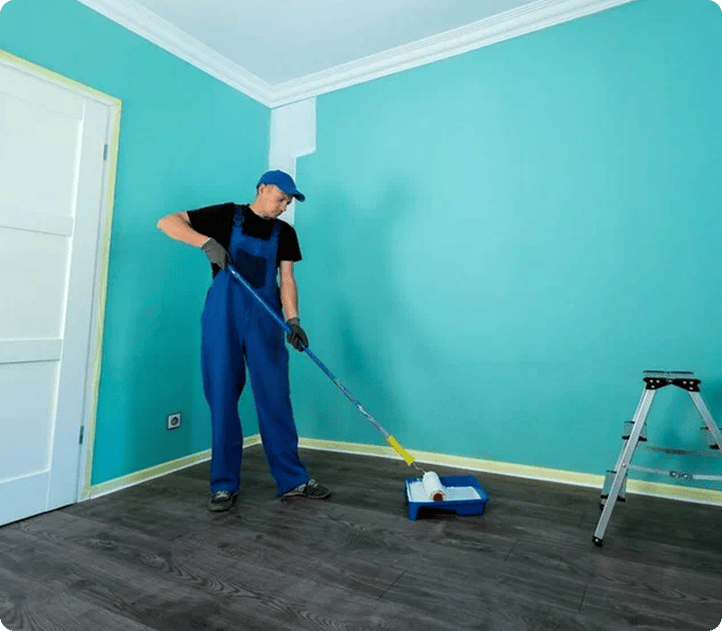 Painter rolling teal paint onto a room wall | Blue Rock Roofing & Construction | Best painting in Fort Mill, SC