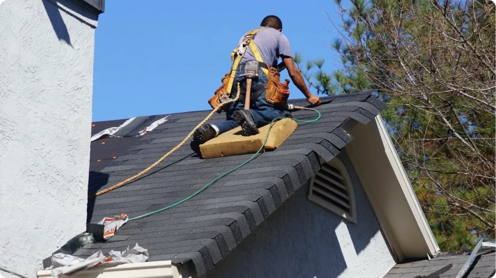 Roofer performing emergency shingle roof repair