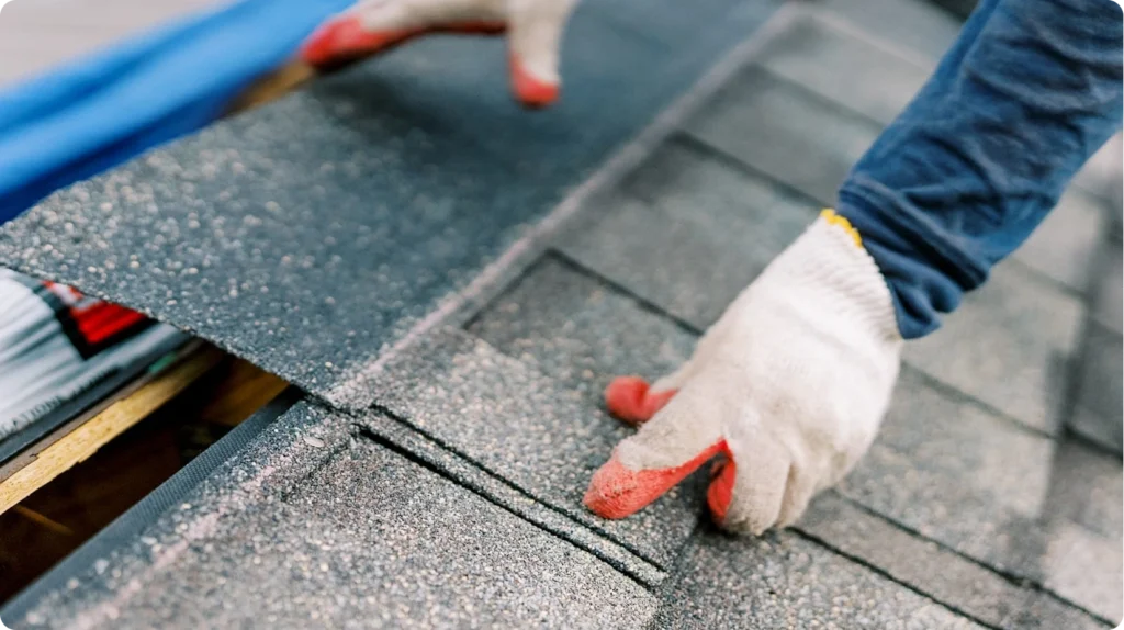 Roofing contractor installing replacement shingles